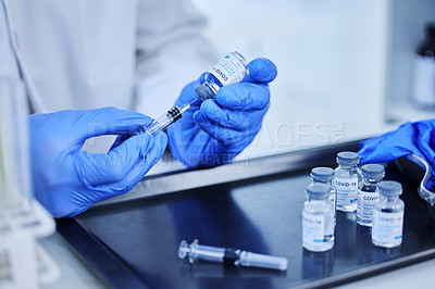 Buy stock photo Cropped shot of an unrecognizable scientist using a syringe to extract the covid 19 vaccine from a bottle in the lab