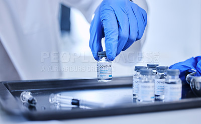 Buy stock photo Cropped shot of an unrecognizable scientist sorting out batches of the covid 19 vaccine on a tray in the lab