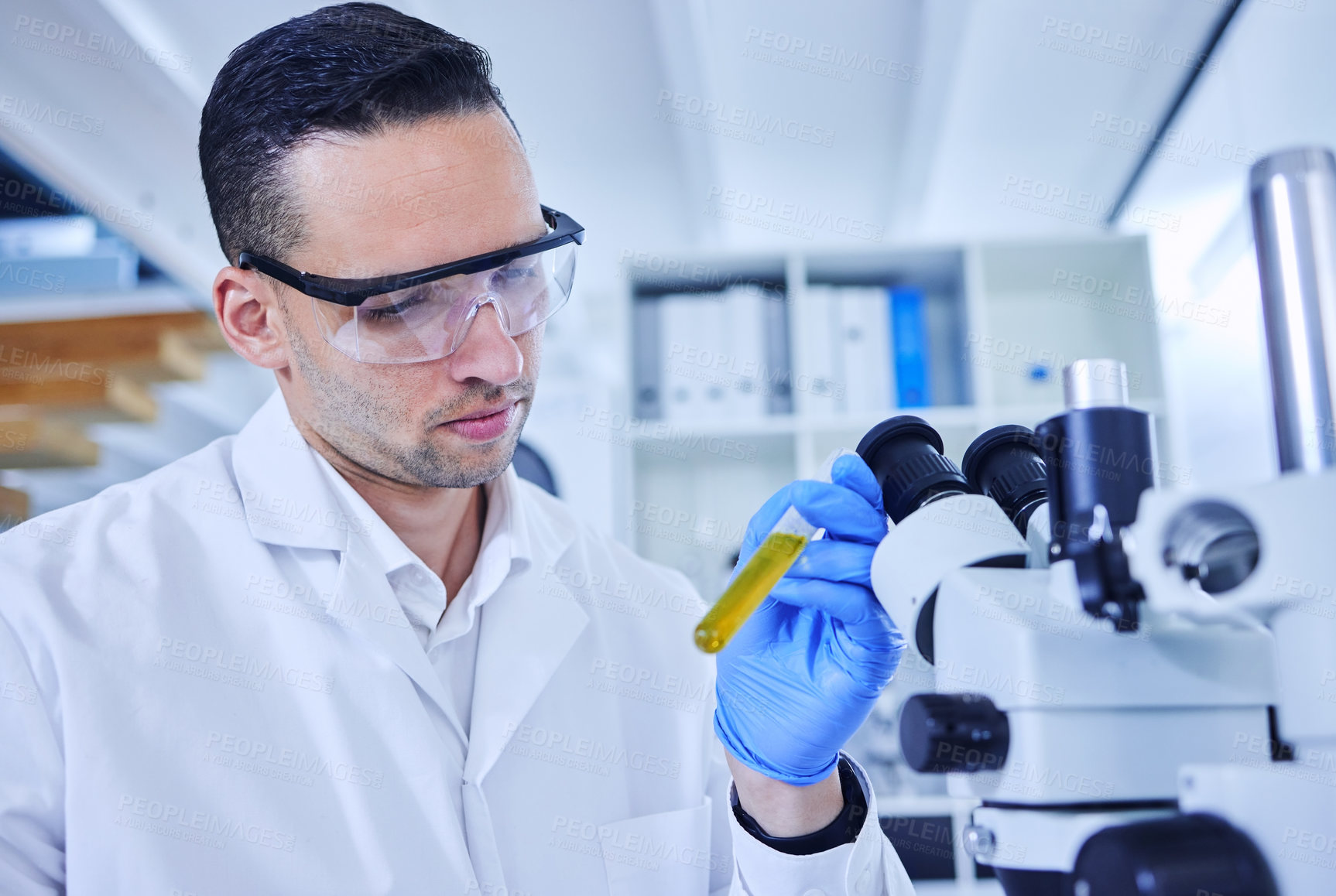 Buy stock photo Man, science and inspection with test tube in lab, innovation with microscope for medical. Healthcare, research and analysis with immune cells for gene therapy, development in biotech with safety