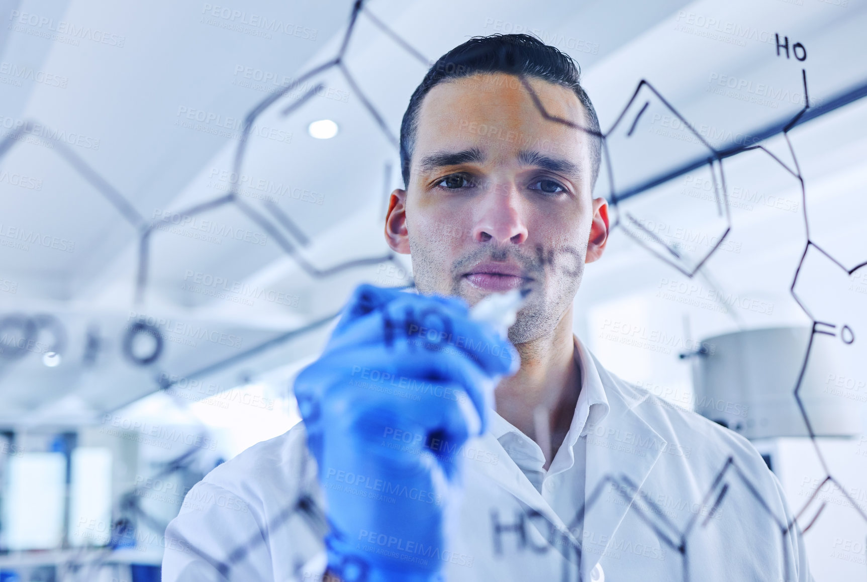 Buy stock photo Cropped shot of a handsome young male scientist working on a glass wipe board in his lab