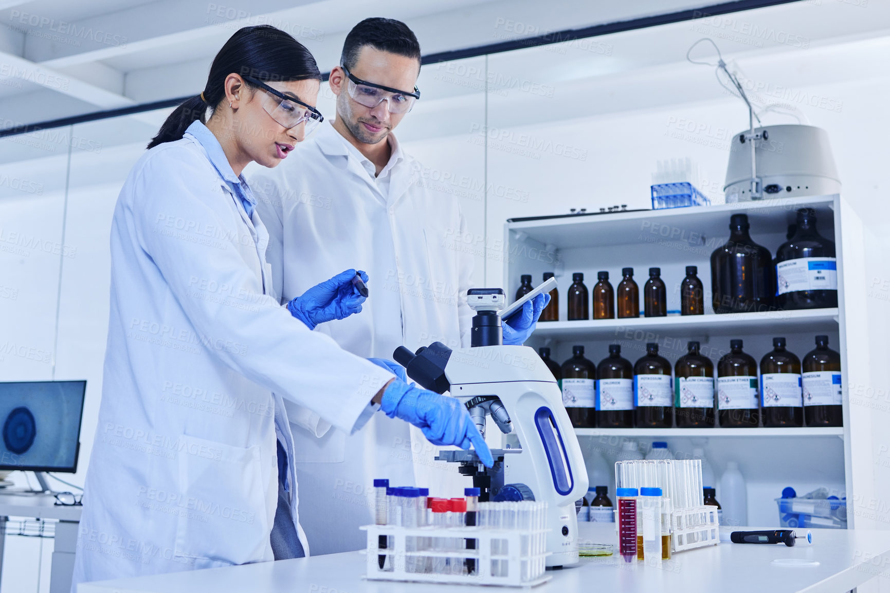 Buy stock photo Team, scientist and microscope in laboratory with sample, safety wear and chemistry together. Man, woman and scientific equipment for research in biochemistry, medicine and experiment results