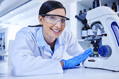 Buy stock photo Cropped portrait of an attractive young female scientist working with a microscope in her lab