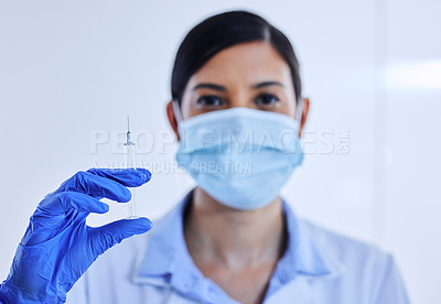 Buy stock photo Cropped shot of an unrecognizable female scientist holding up a syringe containing medication