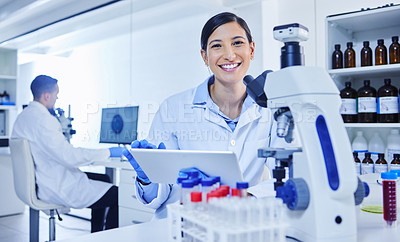 Buy stock photo Cropped portrait of an attractive young female scientist working with a microscope and tablet in her lab
