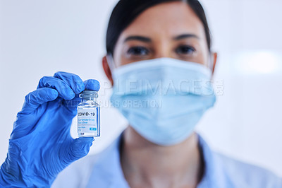 Buy stock photo Cropped shot of an unrecognizable female scientist holding up a bottle of the covid 19 vaccine