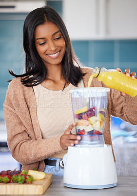 Buy stock photo Shot of a young woman preparing a healthy smoothie at home