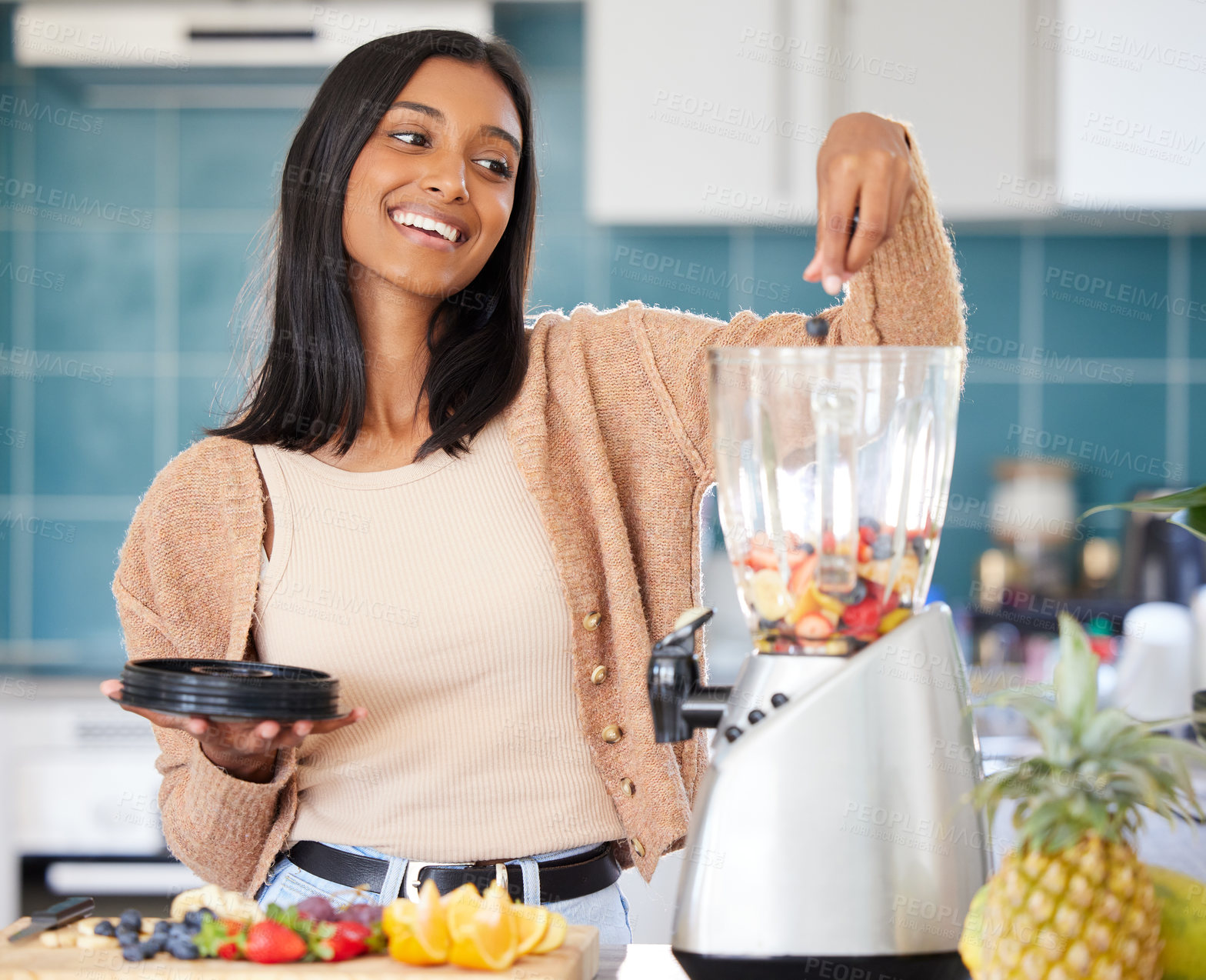 Buy stock photo Shot of a young woman preparing a healthy smoothie at home