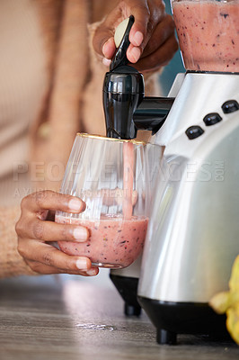 Buy stock photo Closeup shot of an unrecognisable woman pouring a freshly blended smoothie into a glass at home