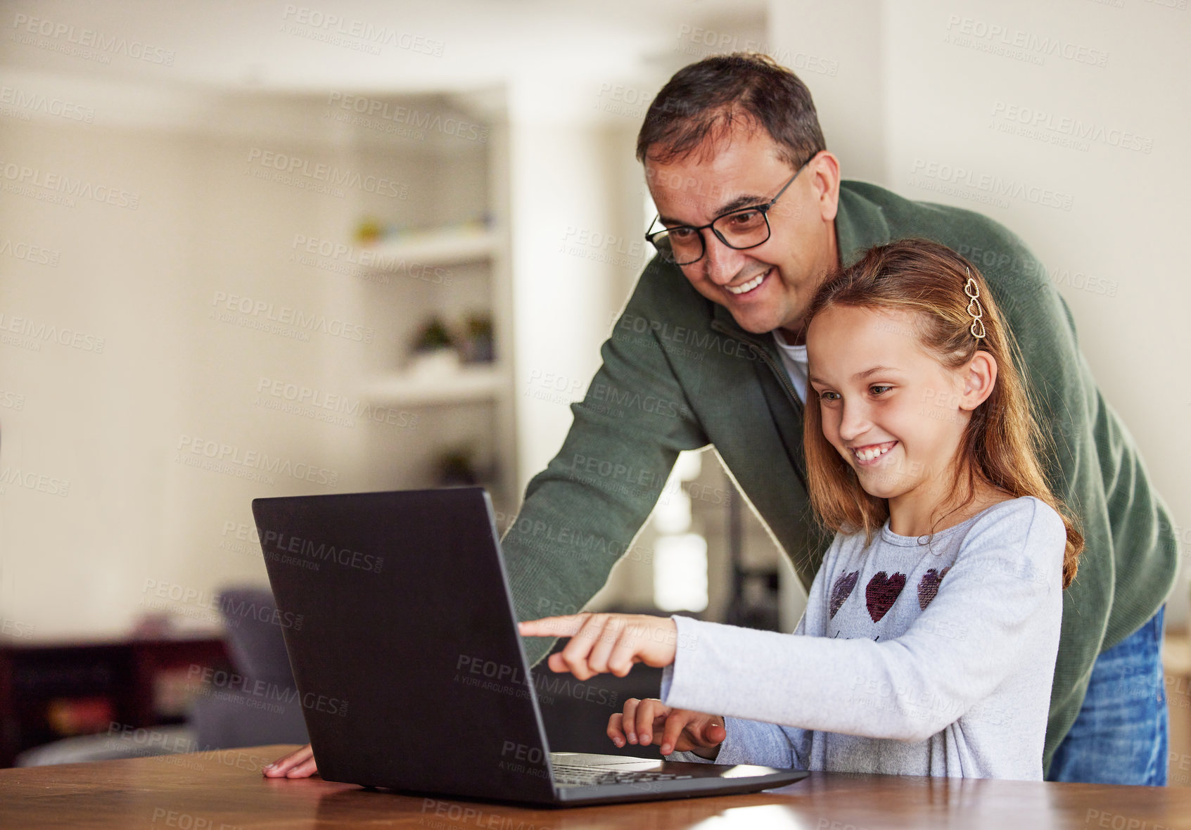 Buy stock photo Father, girl and laptop for remote learning in home, internet and school website or online homework. Daddy, daughter and help with lesson at table, education and studying or teaching child o point