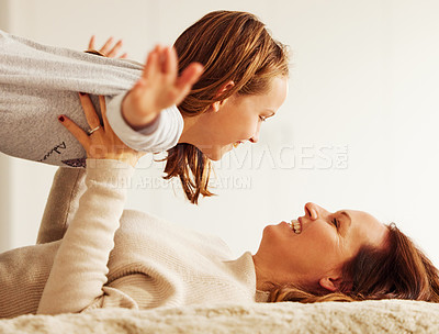 Buy stock photo Mom, girl and happy with plane on bed with smile, care and bonding with games in morning at family home. Airplane, mother and daughter with playful connection, child and relax with love in apartment