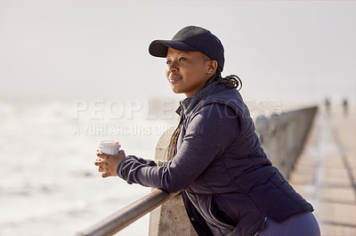 Buy stock photo Shot of a young woman enjoying a cup of coffee by the ocean