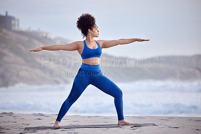 Buy stock photo Black woman, yoga and fitness for wellness at beach with peaceful mind, warrior pose and body. African person, zen and pilates workout at sea with stretching, spirituality and balance with training