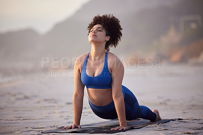 Buy stock photo African woman, yoga and health for wellness at sea with peaceful mind, cobra pose and fitness. African person, zen and pilates workout at beach with stretching, spirituality and calm for mindset
