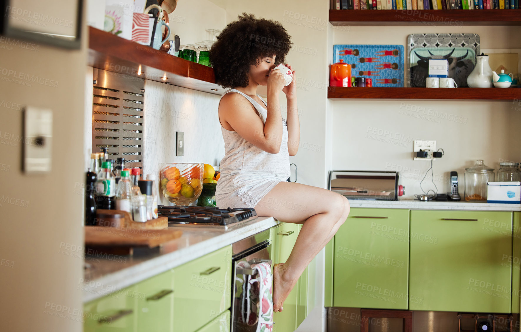 Buy stock photo Kitchen counter, woman and drinking coffee in morning for wake up, relax and hot beverage in house. Gen z girl, drink and sitting on table top for breakfast, energy boost and espresso for wellness
