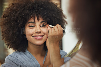 Buy stock photo Shot of a beautiful woman looking in the mirror while applying makeup at home