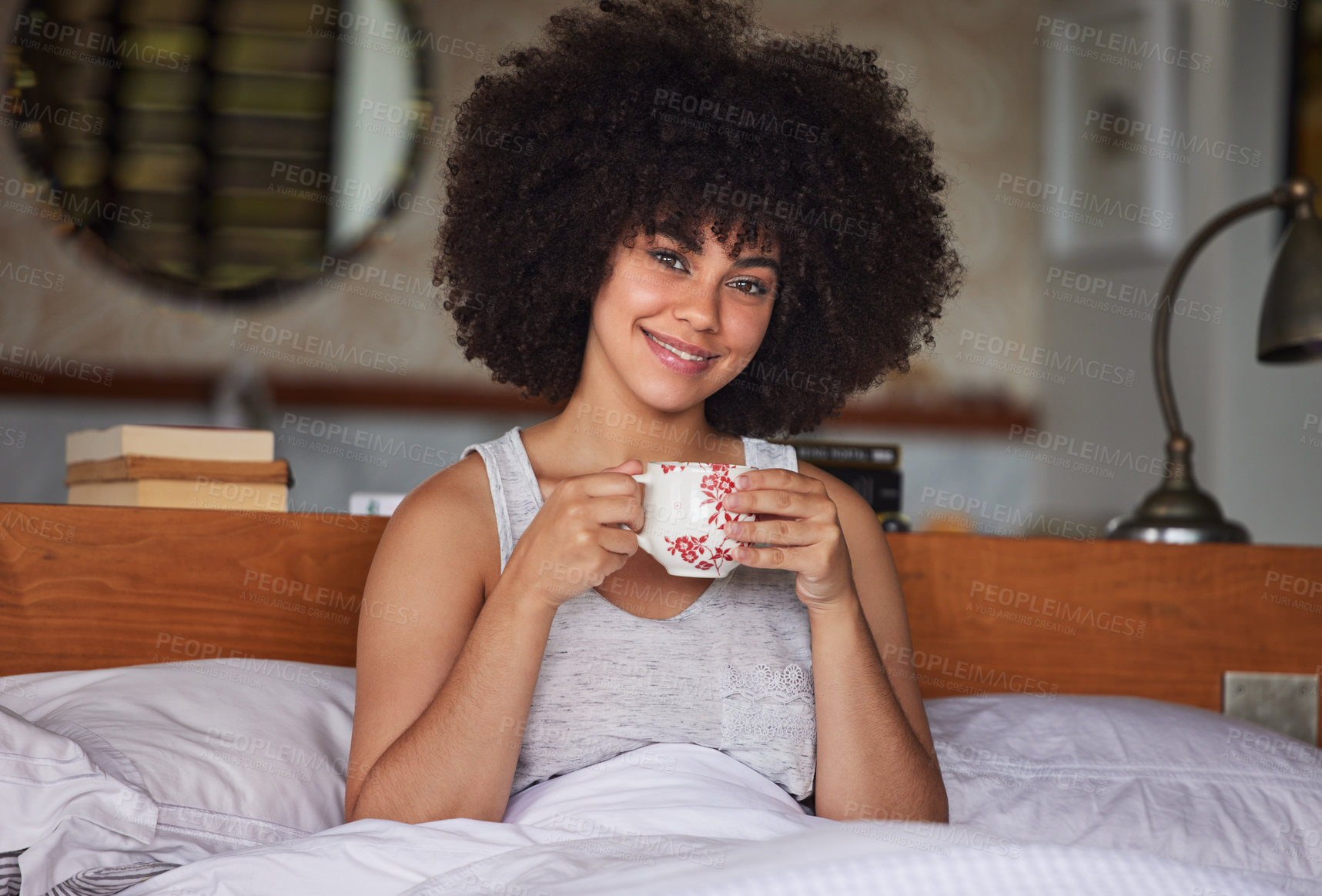 Buy stock photo Portrait of a beautiful  young woman having a cup of coffee in bed at home