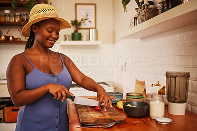 Buy stock photo Happy, black woman or fruit in kitchen with wellness smoothie, balance or detox diet at home. Vitamin, knife and African girl with strawberry for gut health, brunch or salad for superfoods nutrition