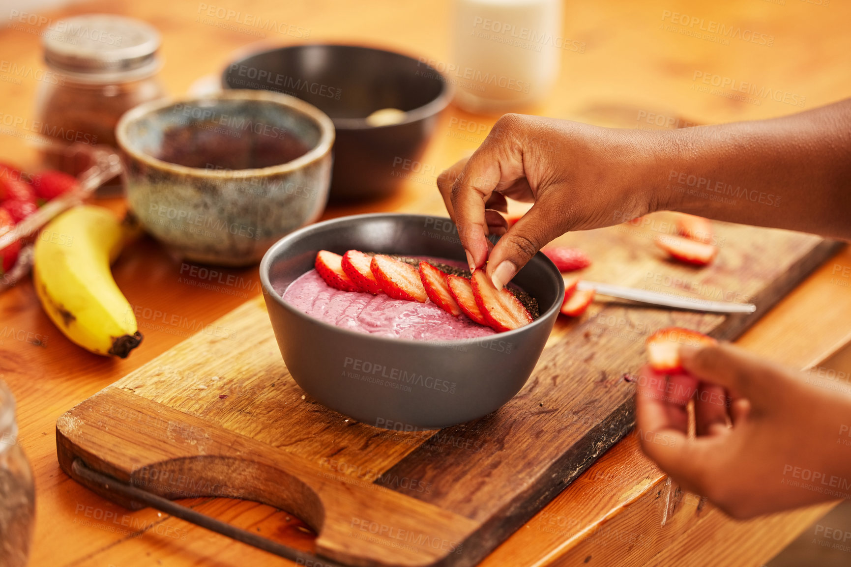 Buy stock photo Hands, fruit and yogurt in home for breakfast, nutrition and meal prep healthy vegan diet on kitchen counter. Food, closeup and person with strawberry bowl, salad and organic banana for wellness