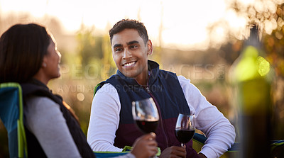 Buy stock photo Shot of a young couple having a glass outside while camping outside