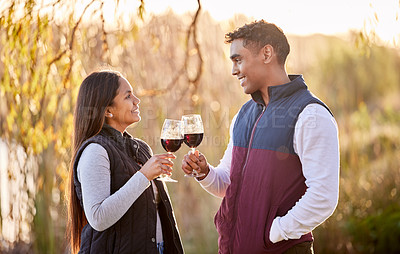 Buy stock photo Shot of a young couple having a glass outside while camping outside