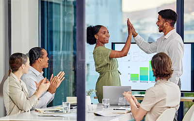 Buy stock photo Shot of a young man and woman high fiving one another in a meeting in a modern office