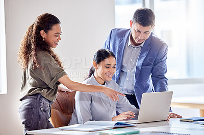 Buy stock photo Shot of a group of colleagues using a laptop in an office at work