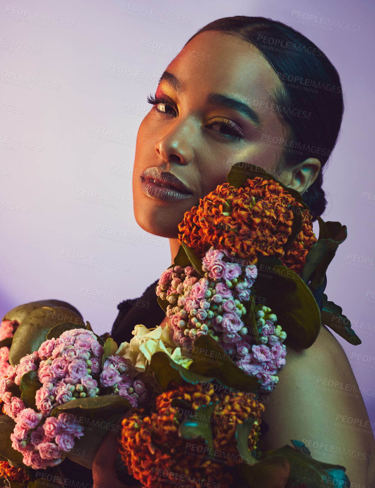 Buy stock photo Studio portrait of an attractive young woman posing with a bouquet against a colourful background