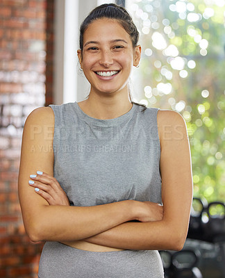 Buy stock photo Shot of a young woman posing and smiling in a gym