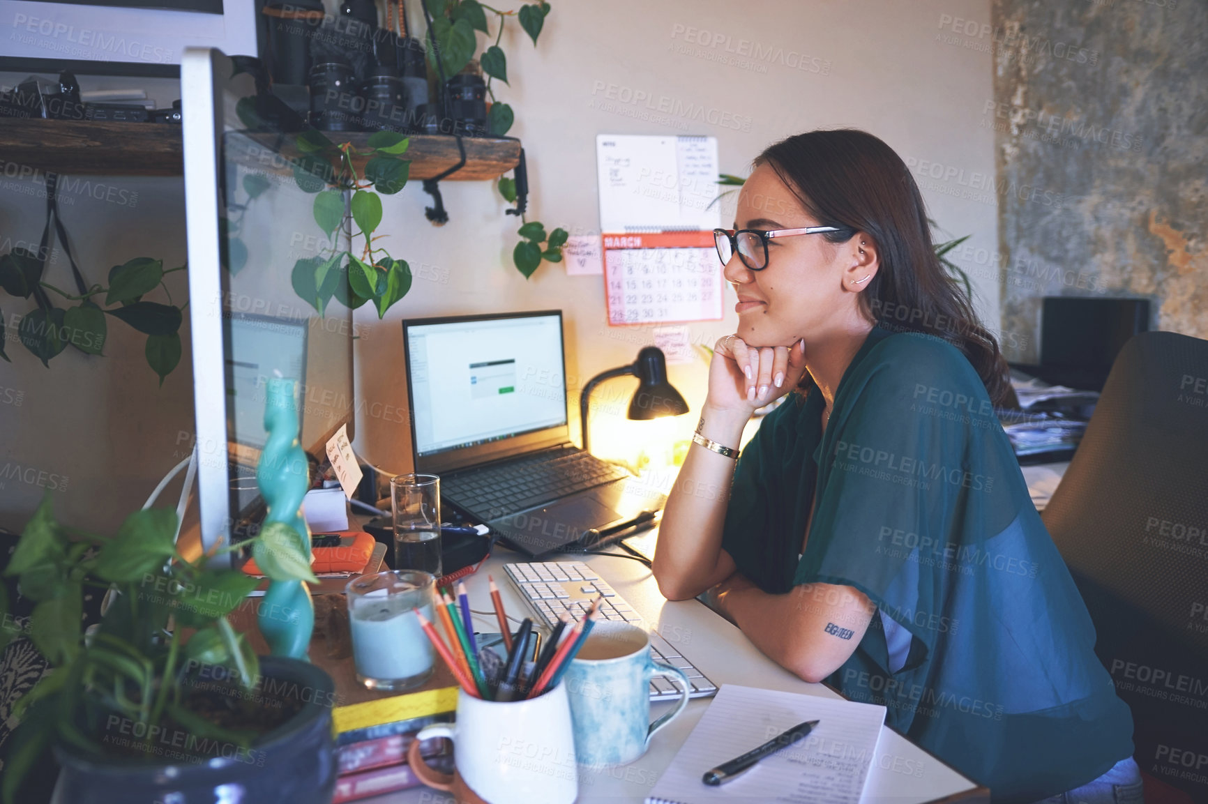 Buy stock photo Shot of an attractive young woman sitting alone and using her computer to work from home