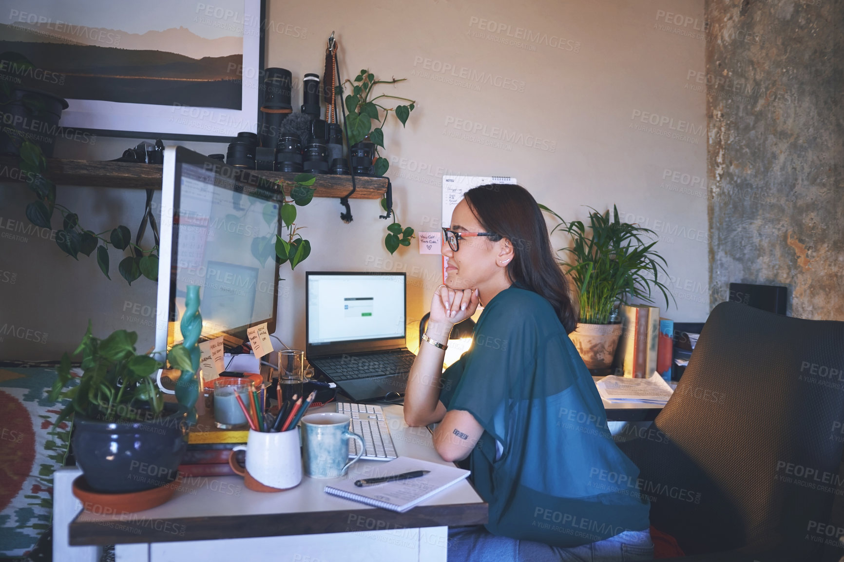 Buy stock photo Shot of an attractive young woman sitting alone and using her computer to work from home