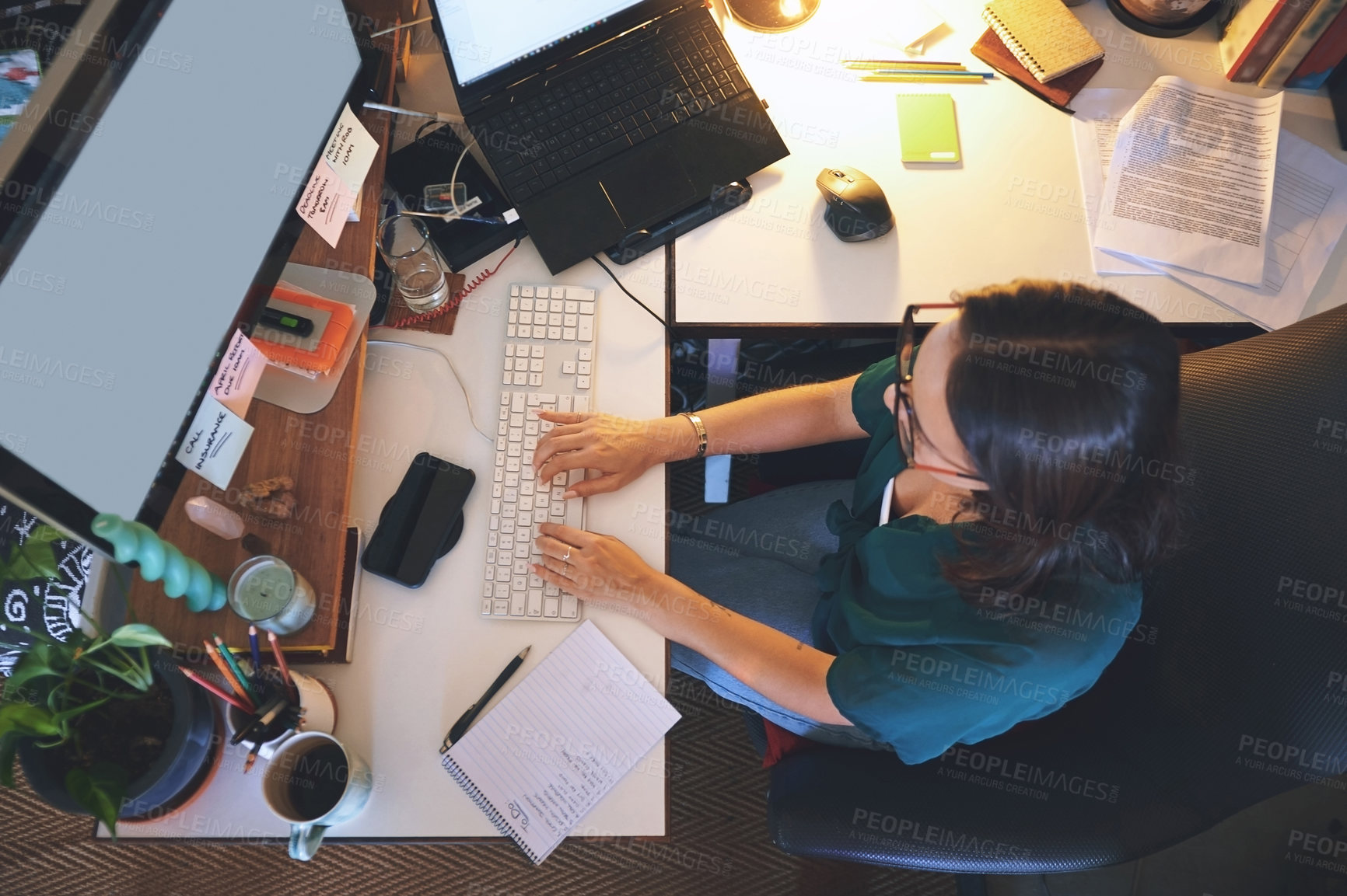 Buy stock photo High angle shot of an unrecognizable woman sitting alone and using her computer to work from home