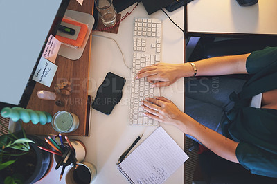Buy stock photo High angle shot of an unrecognizable woman sitting alone and using her computer to work from home