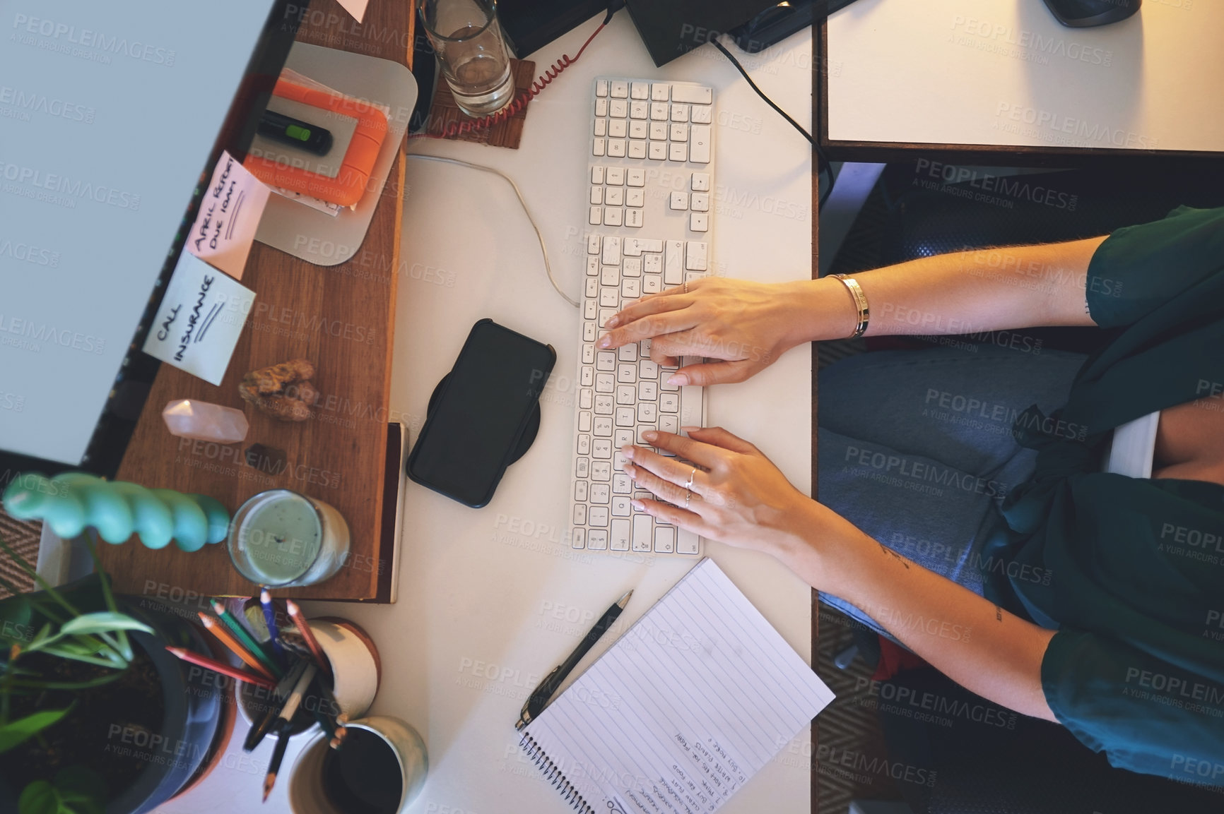 Buy stock photo High angle shot of an unrecognizable woman sitting alone and using her computer to work from home