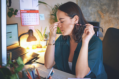 Buy stock photo Shot of an attractive young woman sitting alone and feeling stressed while using her computer to work from home