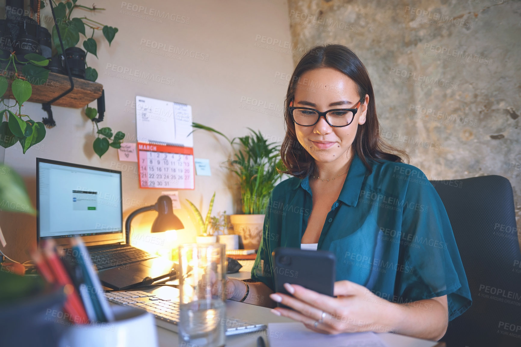 Buy stock photo Shot of an attractive young woman sitting alone and using her cellphone to work from home