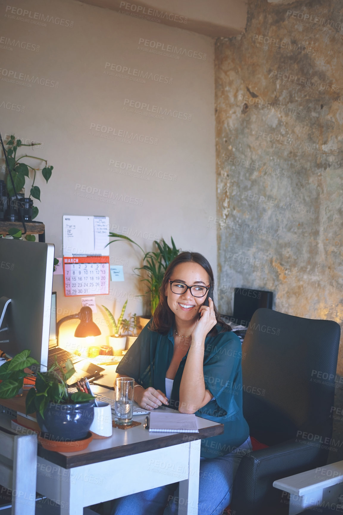 Buy stock photo Shot of an attractive young woman sitting alone and using her cellphone while working from home