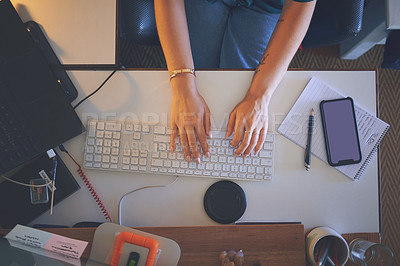 Buy stock photo High angle shot of an unrecognizable woman sitting alone and using her computer to work from home