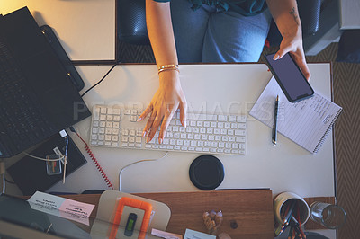 Buy stock photo High angle shot of an unrecognizable woman sitting alone and using her computer to work from home