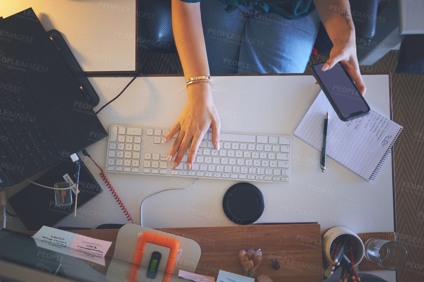 Buy stock photo High angle shot of an unrecognizable woman sitting alone and using her computer to work from home