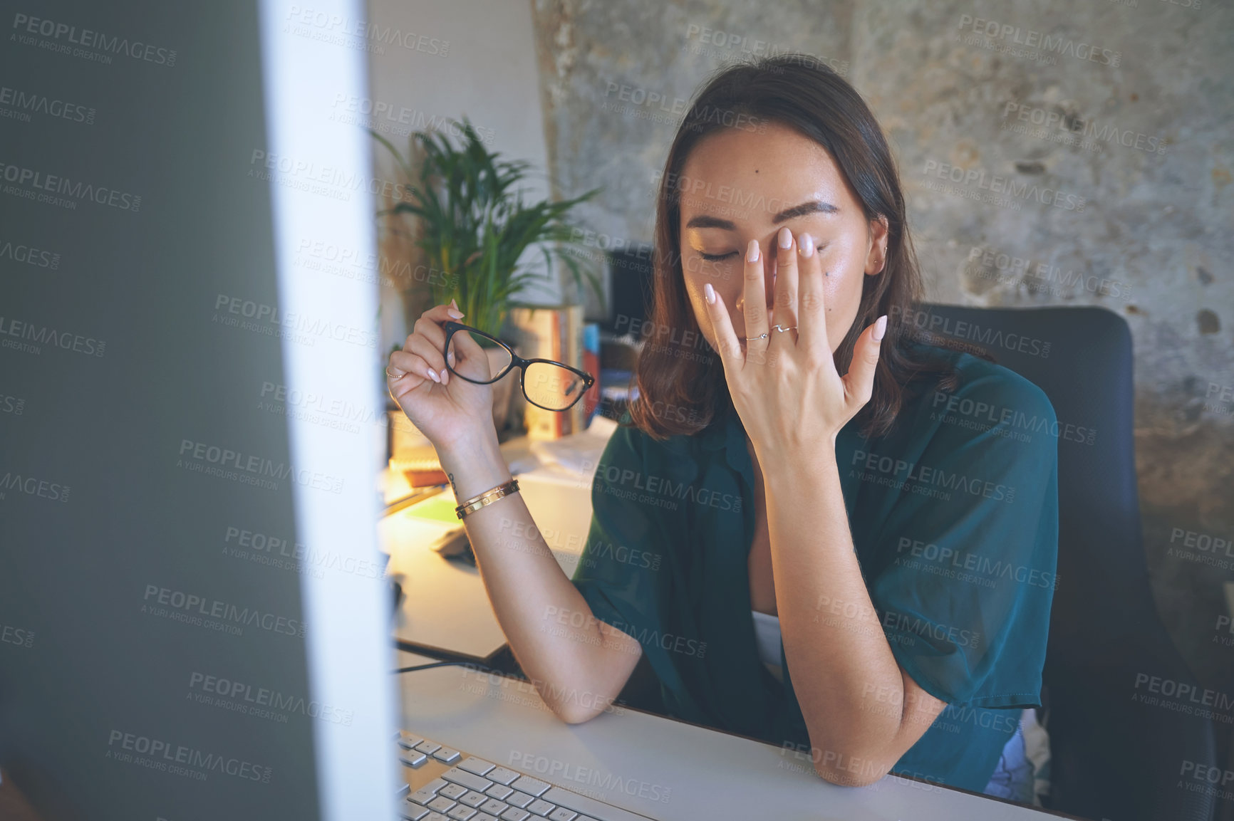 Buy stock photo Shot of an attractive young woman sitting alone and feeling stressed while using her computer to work from home