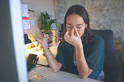 Buy stock photo Shot of an attractive young woman sitting alone and feeling stressed while using her computer to work from home