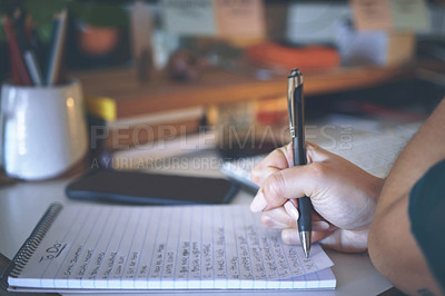 Buy stock photo Cropped shot of an unrecognizable woman sitting alone and writing notes while working from home