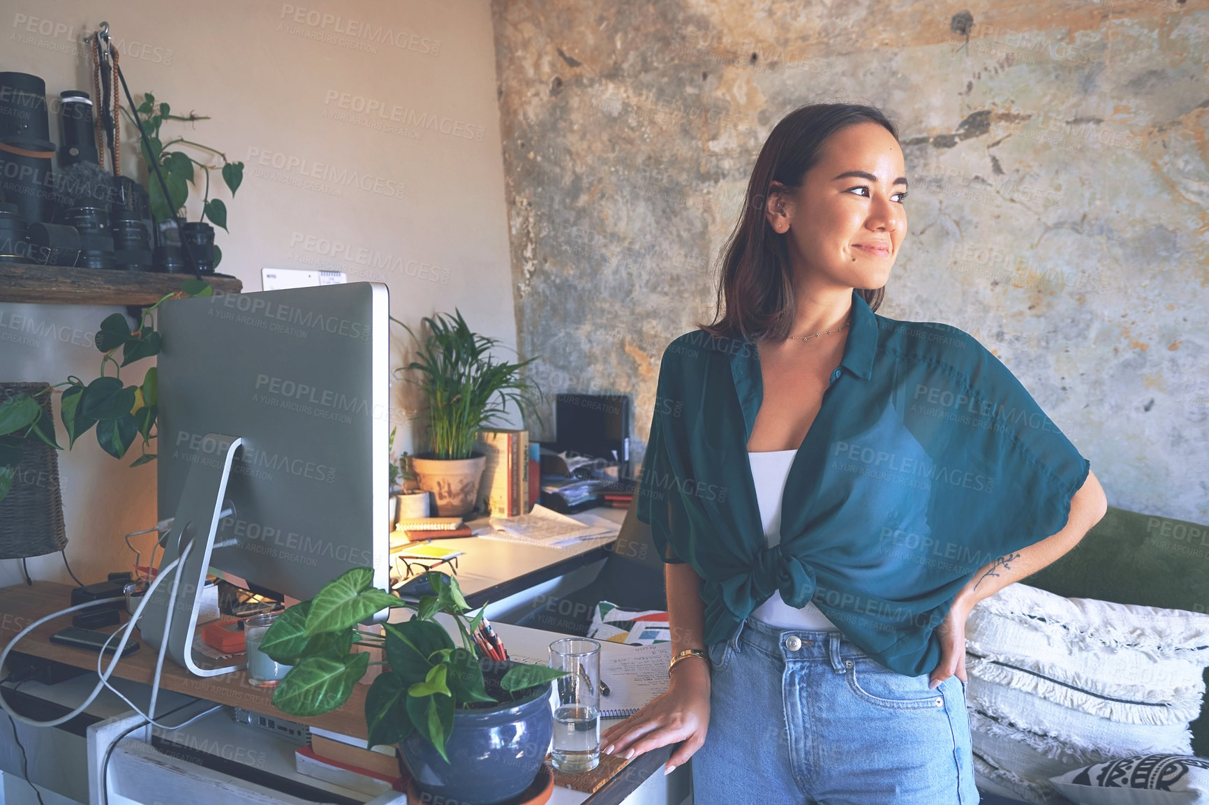 Buy stock photo Shot of an attractive young woman standing alone in her home office during the day