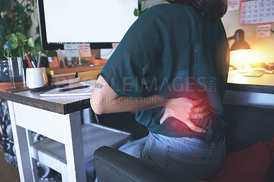 Buy stock photo Cropped shot of an unrecognizable woman sitting and suffering from back ache while using her computer to work from home