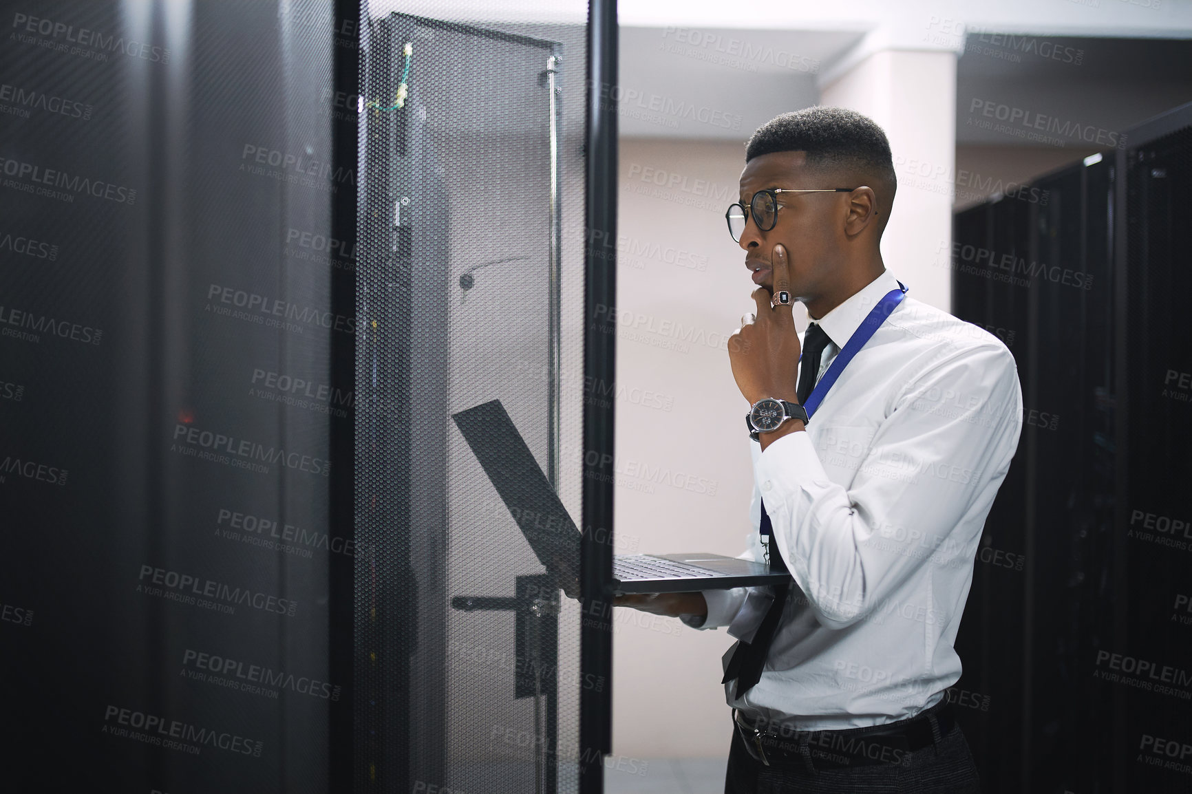 Buy stock photo Black man, engineer and troubleshooting with laptop in server room for software, hardware or network repair. Male person, IT technician or thinking with computer for problem solving or system backup