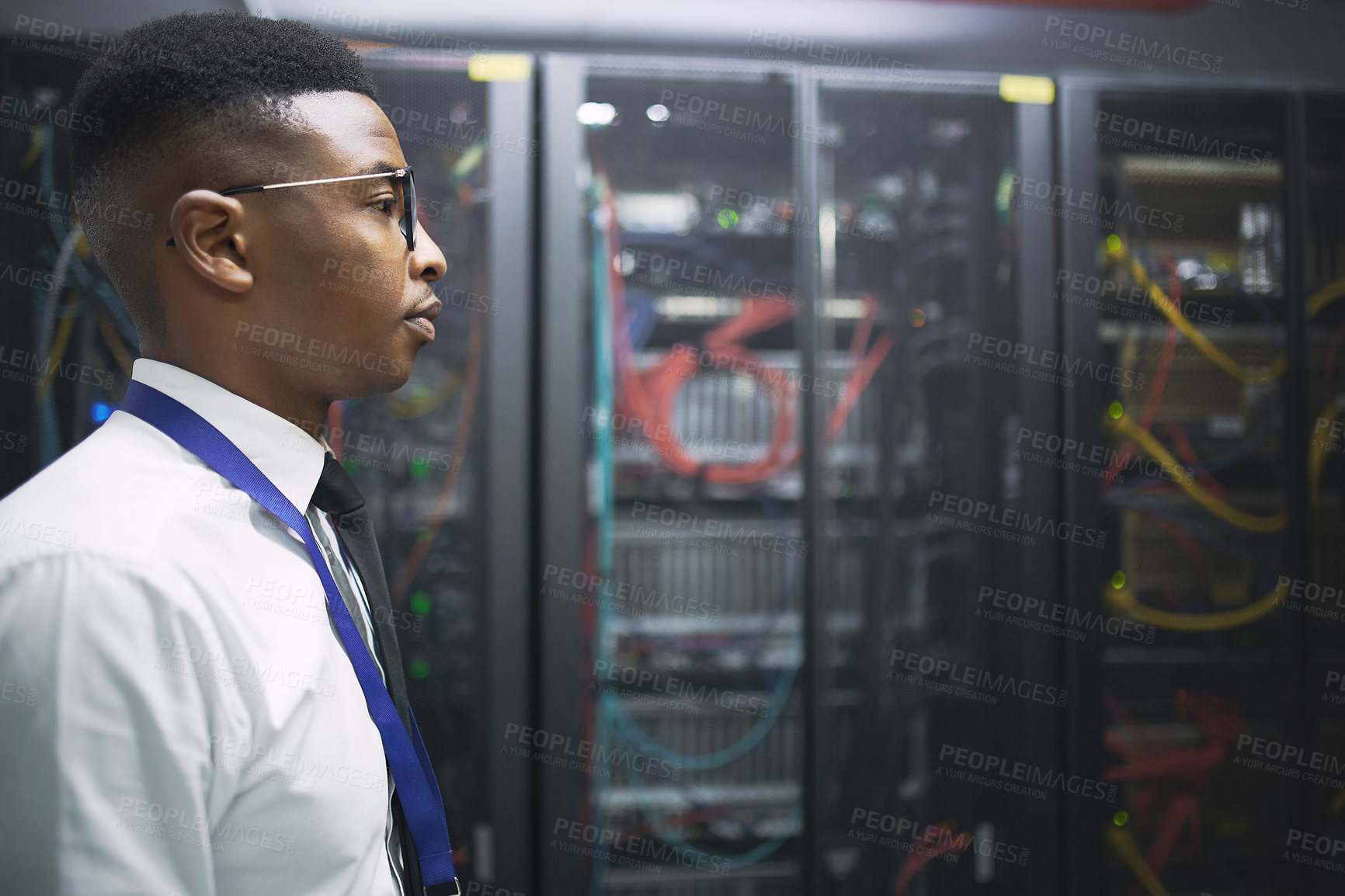 Buy stock photo Shot of a young male IT technician in a server room