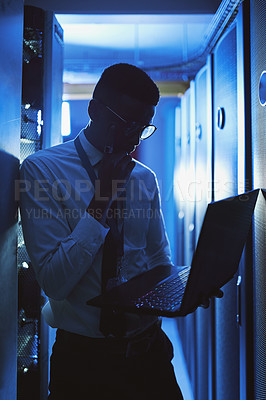 Buy stock photo Shot of a young man working in an IT server room