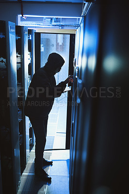 Buy stock photo Shot of a hacker using a digital tablet in a server room