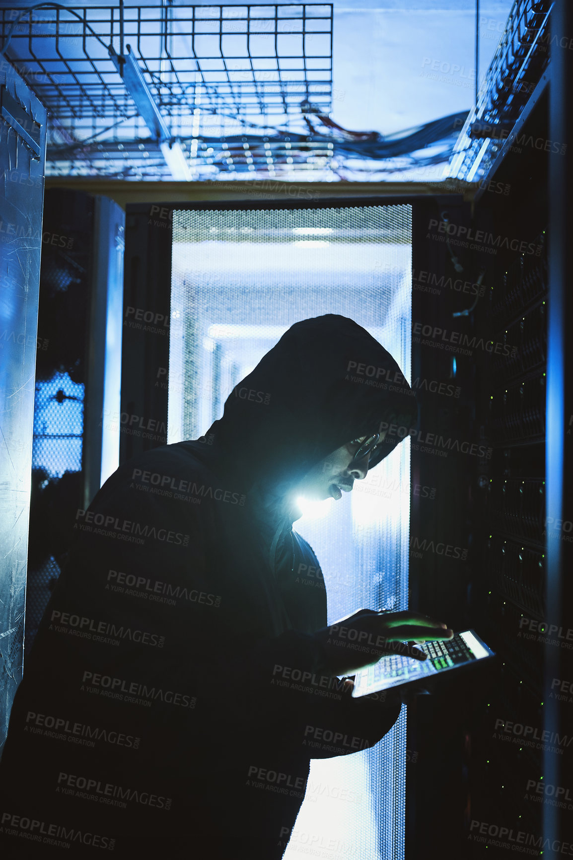 Buy stock photo Shot of a hacker using a digital tablet in a server room