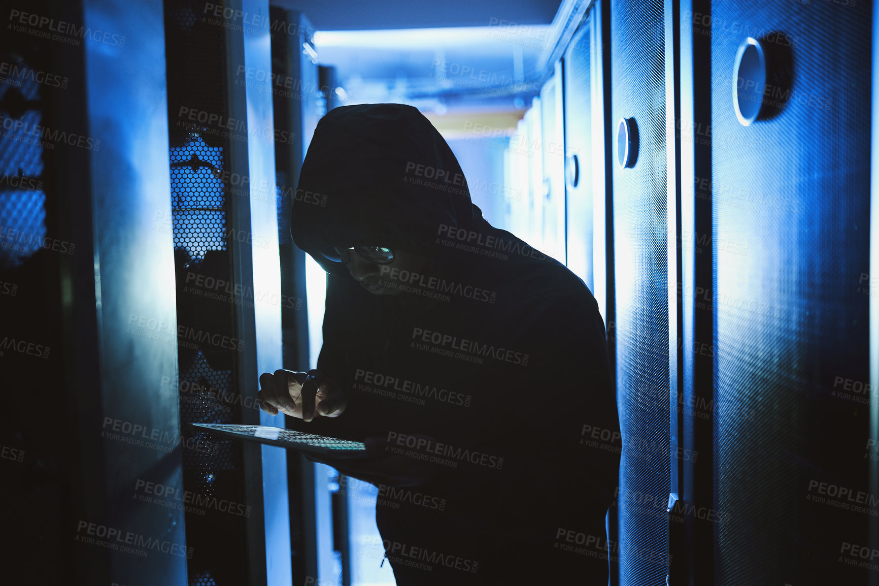 Buy stock photo Shot of a hacker using a digital tablet in a server room